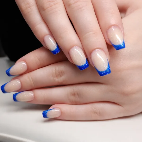A soft  champagne shimmer base finished with a vibrant cobalt french tip. Clean, glossy and confidently bold while still beautifully wearable.